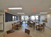 Thumbnail 6 of 15 - a common area with tables and chairs