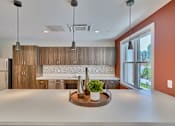 Thumbnail 31 of 32 - A modern kitchen with a large island in the middle.