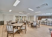 Thumbnail 30 of 32 - A large room with a dining table and chairs.