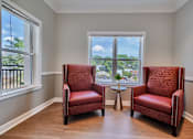 Thumbnail 23 of 32 - Two red chairs are placed in front of a window.