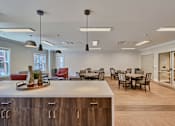 Thumbnail 21 of 32 - A modern kitchen with a dining table and chairs.