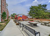 Thumbnail 17 of 32 - A playground with a slide and picnic tables.
