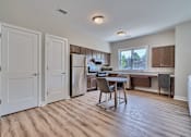 Thumbnail 4 of 32 - A kitchen with a table and chairs in the middle of the room.