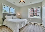 Thumbnail 9 of 32 - A bedroom with a large bed and a window overlooking a building.