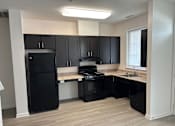 Thumbnail 7 of 30 - A kitchen with black appliances and cabinets.