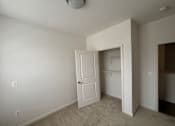 Thumbnail 25 of 30 - A white door is open in a room with a light colored carpet.