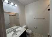 Thumbnail 16 of 30 - A bathroom with a sink, mirror, toilet, and a towel rack.