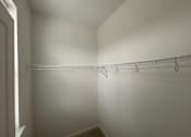 Thumbnail 15 of 30 - A white closet with a metal rack on the wall.