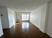 Thumbnail 21 of 26 - A room with wooden flooring and white walls.