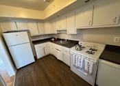 Thumbnail 14 of 29 - A kitchen with white appliances and cabinets.