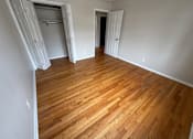 Thumbnail 17 of 29 - A room with wooden flooring and white walls.