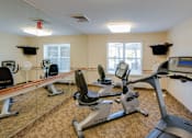 Thumbnail 17 of 17 - A gym with treadmills, elliptical machines, and exercise bikes.