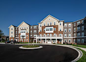 Thumbnail 1 of 54 - a roundabout in front of an apartment building with a blue sky background