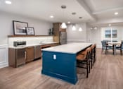 Thumbnail 18 of 54 - a kitchen with a blue island and a dining room with chairs