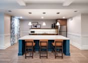 Thumbnail 30 of 54 - a kitchen with a blue island and wooden chairs