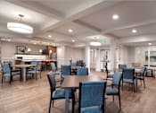 Thumbnail 14 of 54 - a community room with tables and chairs and a kitchen