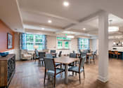 Thumbnail 13 of 54 - a community room with tables and chairs and a kitchen