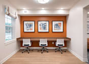 Thumbnail 36 of 54 - a conference room with four chairs and a desk with three pictures on the wall