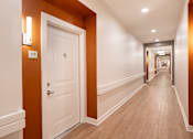Thumbnail 43 of 54 - a corridor with a white door and a hallway with orange walls