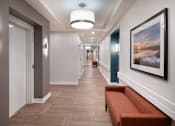 Thumbnail 24 of 54 - a long hallway with a bench and a painting on the wall