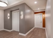 Thumbnail 39 of 54 - a corridor with a white door and grey walls and a wooden floor
