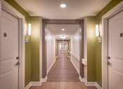Thumbnail 35 of 54 - a hallway with green walls and wooden floors and white doors