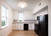 Thumbnail 48 of 54 - a kitchen with white cabinets and a black refrigerator