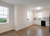 Thumbnail 27 of 54 - an empty kitchen with white cabinets and a wooden floor and a window