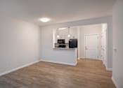 Thumbnail 44 of 54 - a living room and kitchen with a wood floor and white walls