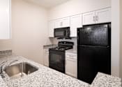 Thumbnail 46 of 54 - a kitchen with granite counter tops and black appliances
