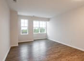 Thumbnail 50 of 54 - an empty living room with white walls and wood floors