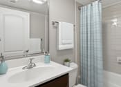 Thumbnail 4 of 37 - A white bathroom with a blue vase on the sink.