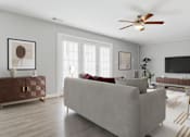 Thumbnail 3 of 37 - A living room with a grey couch, a brown side table, and a ceiling fan.