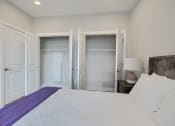 Thumbnail 40 of 43 - a bedroom with a white bed and a closet with white doors