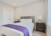 Thumbnail 37 of 43 - a bedroom with a large white bed and a purple blanket