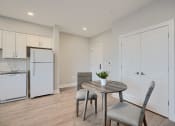 Thumbnail 35 of 43 - a dining room with a table and chairs and a kitchen with a refrigerator