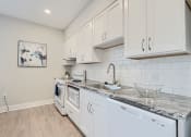 Thumbnail 32 of 43 - an open kitchen with white cabinets and appliances and a sink