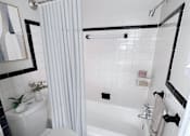 Thumbnail 4 of 29 - A white bathroom with a toilet, sink, and bathtub.