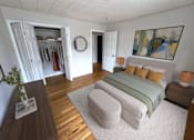 Thumbnail 2 of 29 - A bedroom with a bed, a wardrobe, and a mirror.