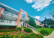 Thumbnail 8 of 29 - A row of houses with a flower bed in front of them.
