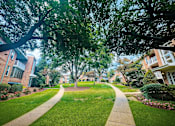 Thumbnail 7 of 29 - A tree-lined walkway leads through a residential neighborhood.