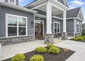 Thumbnail 66 of 74 - the front porch of a gray house with a concrete walkway