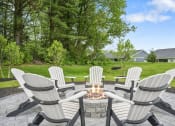 Thumbnail 64 of 74 - a group of white chairs around a fire pit on a patio