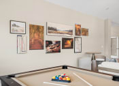 Thumbnail 37 of 74 - a living room with a pool table and pictures on the wall