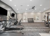 Thumbnail 49 of 74 - a gym with treadmills and televisions on the wall
