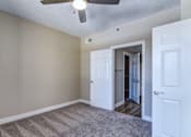 Thumbnail 26 of 41 - A room with a ceiling fan and a carpeted floor.