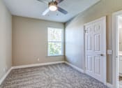 Thumbnail 25 of 41 - A room with a ceiling fan and a door.