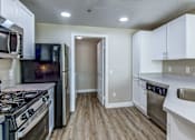 Thumbnail 27 of 41 - A kitchen with a black refrigerator, stove, and oven.