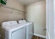 Thumbnail 21 of 41 - Two white front loading washing machines in a small laundry room.