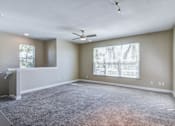Thumbnail 18 of 41 - A spacious room with a ceiling fan and large windows.
